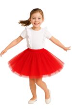 Dziewczynka około siedmiu lat tańczy z uśmiechem, ubrana w białą koszulkę z falbankami i czerwoną tiulową spódniczkę. Ma niebieskie oczy, brązowe włosy związane w kucyk i białe baleriny. Zdjęcie wykonane na jasnym, jednolitym tle.
